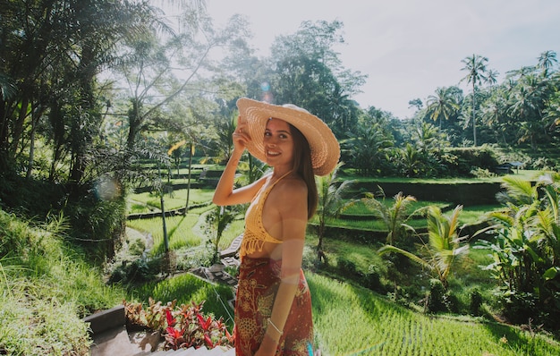 Menina bonita que visita os campos do arroz de Bali em tegalalang, ubud. Conceito sobre pessoas, desejo de viajar e estilo de vida turístico