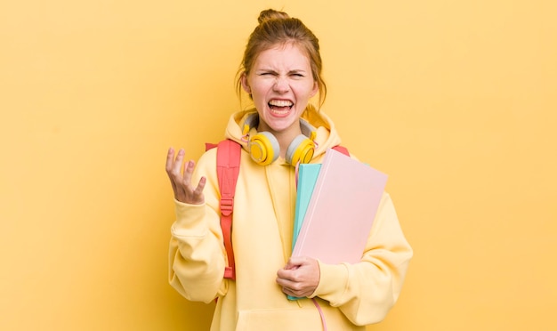 Menina bonita ruiva olhando irritado, irritado e frustrado conceito de estudante