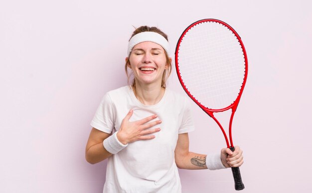Menina bonita ruiva rindo alto de algum conceito de tênis de piada hilária