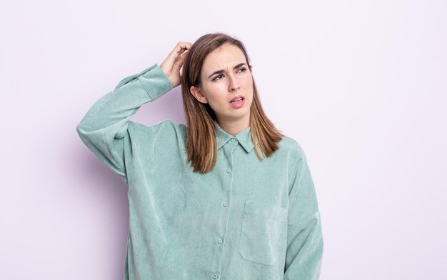 Menina bonita se sentindo perplexa e confusa, coçando a cabeça e olhando para o lado