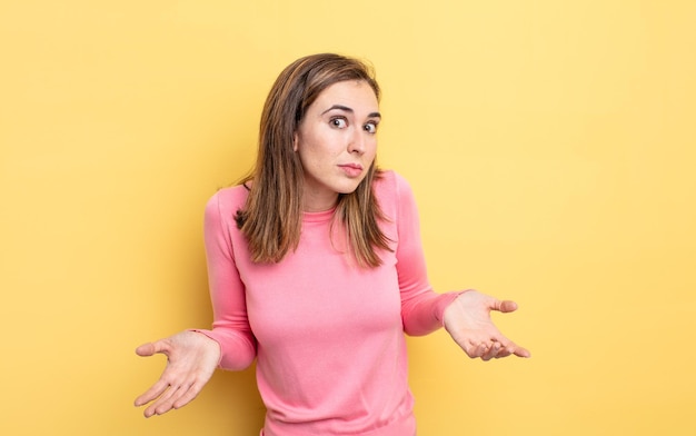 Menina bonita se sentindo sem noção e confusa, sem fazer ideia, absolutamente intrigada com um olhar idiota ou tolo