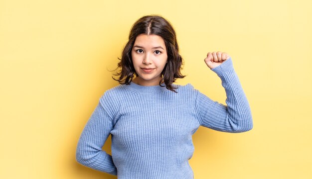 Menina bonita se sentindo séria, forte e rebelde, levantando o punho, protestando ou lutando pela revolução