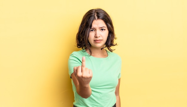 Menina bonita se sentindo zangada, irritada, rebelde e agressiva, sacudindo o dedo do meio, lutando contra