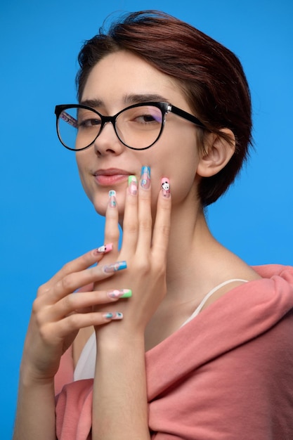 Menina bonita sensual com corte de cabelo curto e arte de unhas extravagante