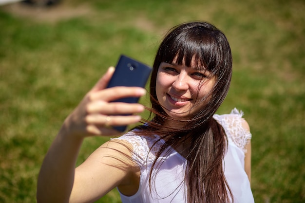 Menina bonita sentada no parque, verão