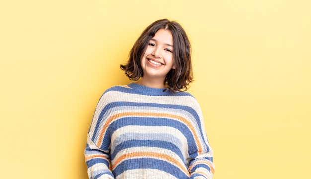 Menina bonita sorrindo alegre e casualmente com uma expressão positiva, feliz, confiante e relaxada