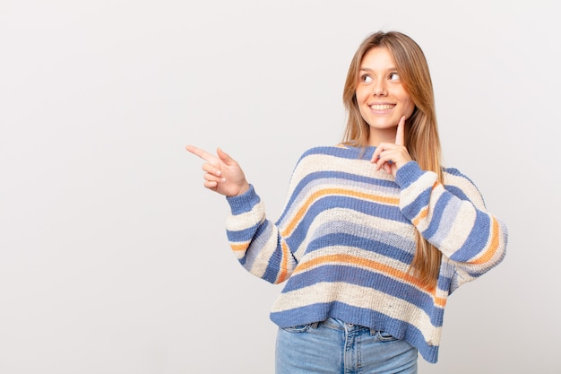 Menina bonita sorrindo feliz e sonhando acordada ou duvidando