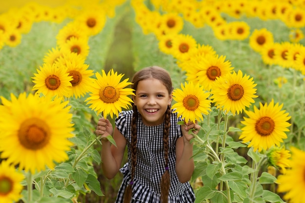 Menina bonita sorrindo no campo de girassol