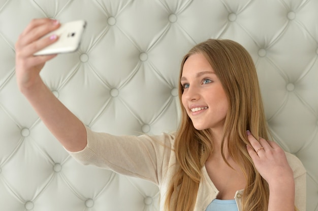 Menina bonita tirando uma selfie com seu telefone inteligente