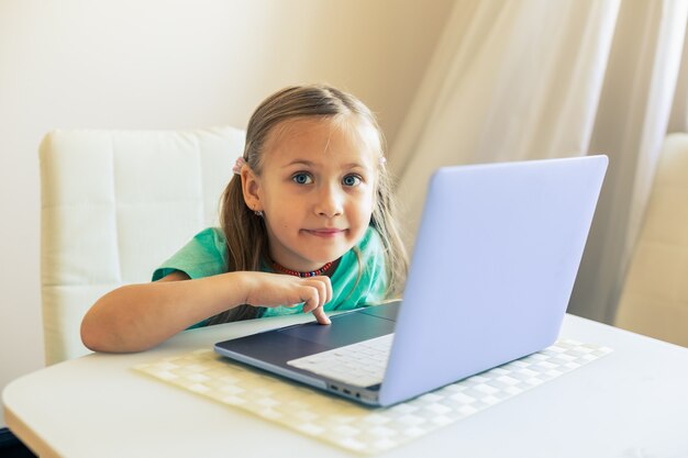 Menina bonita usando laptop para fazer videochamada