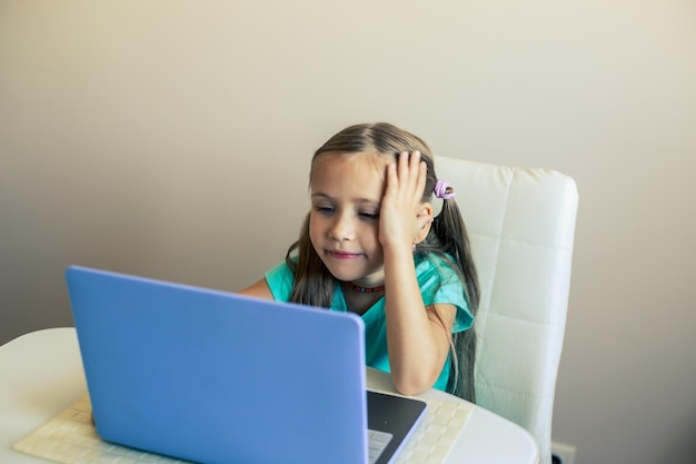 Foto menina bonita usando laptop para fazer videochamada