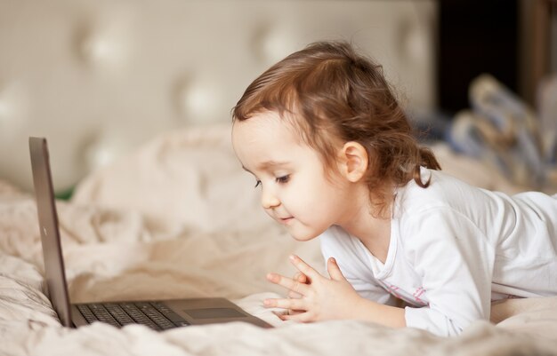 Menina bonita, usando um laptop digital