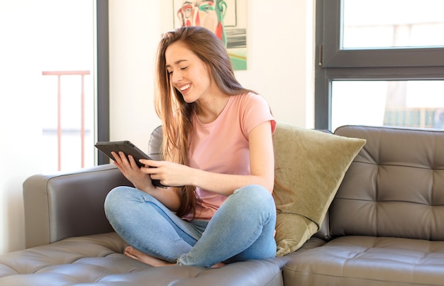 Menina bonita usando um tablet pad em casa