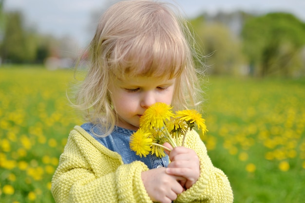 Menina bonitinha andando no parque com flores-leão