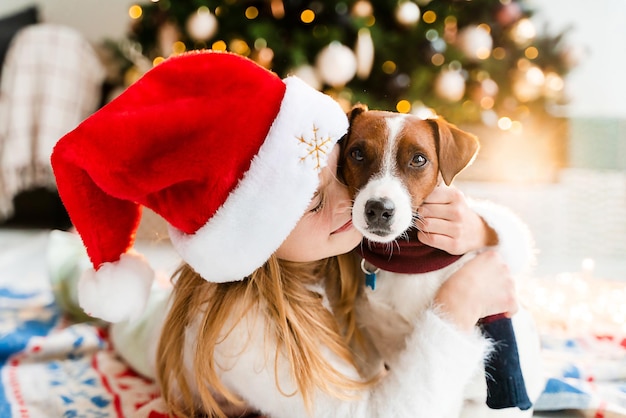 Menina bonitinha aproveitando o Natal com seu cachorro