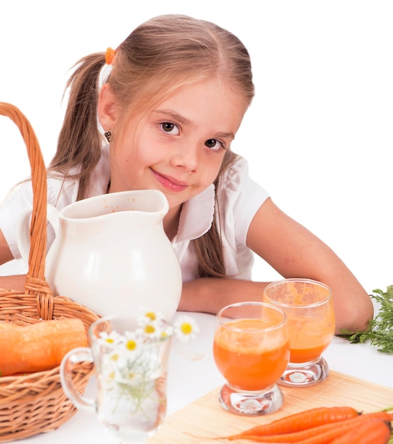 Menina bonitinha beber suco de cenoura. fundo branco