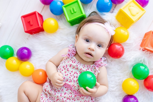 Menina bonitinha brincando com brinquedos coloridos