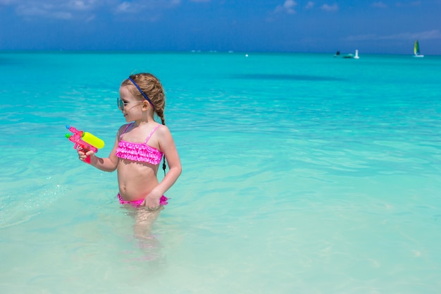 Menina bonitinha brincando com brinquedos durante as férias do Caribe