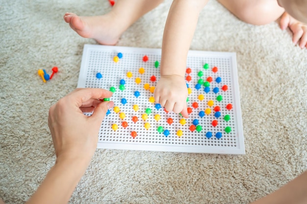 Menina bonitinha brincando com mosaico de unhas de cogumelo pai e bebê brincando juntos conceito hobby e...