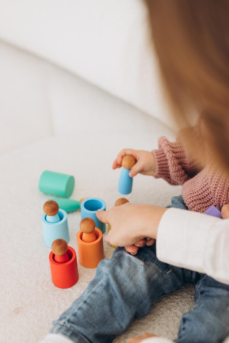 Menina bonitinha brincando em casa com brinquedos ecológicos de madeira Criança feliz cortando legumes e frutas com faca de brinquedo A criança jogando jogos educativos