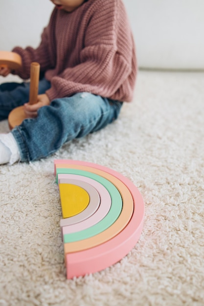 Menina bonitinha brincando em casa com brinquedos ecológicos de madeira Criança feliz cortando legumes e frutas com faca de brinquedo A criança jogando jogos educativos