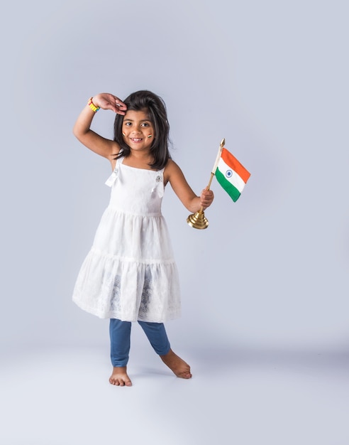 Menina bonitinha com a bandeira tricolor nacional indiana, isolada sobre fundo branco. Adequado para o conceito do Dia da Independência ou Dia da República