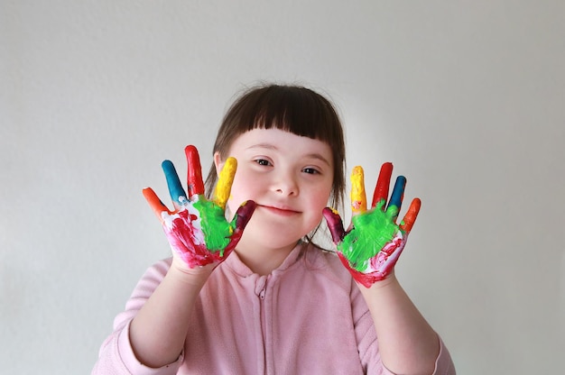 Menina bonitinha com as mãos pintadas. Isolado no fundo branco.