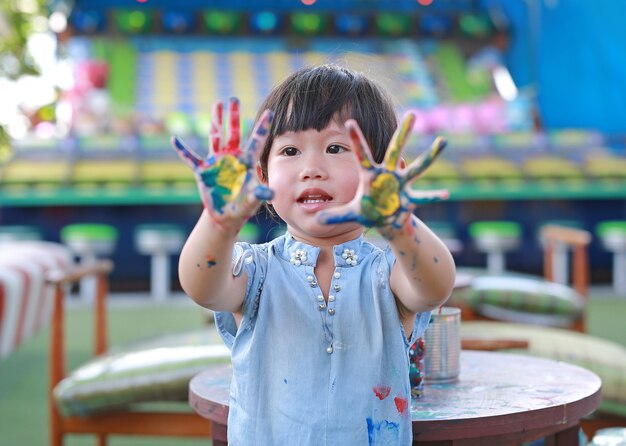 Menina bonitinha com as mãos pintadas