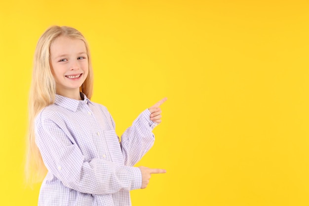 Menina bonitinha com camisa em fundo amarelo