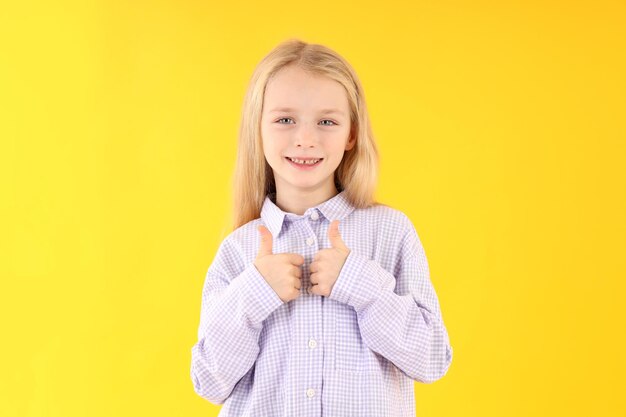 Menina bonitinha com camisa em fundo amarelo