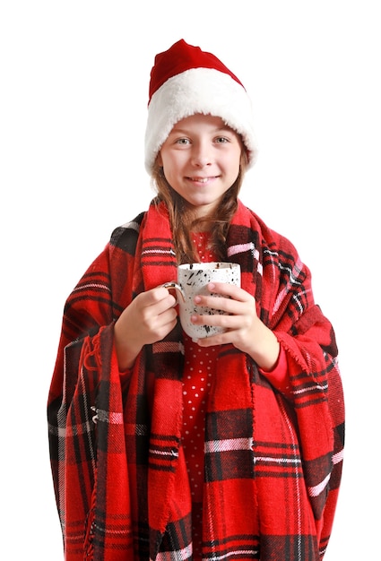 Menina bonitinha com chapéu de Papai Noel e com uma xícara de chocolate quente no branco