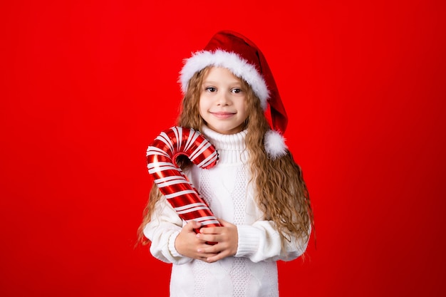 Menina bonitinha com chapéu de papai noel e um suéter