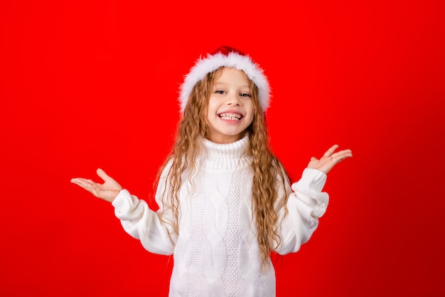 Menina bonitinha com chapéu de Papai Noel e um suéter