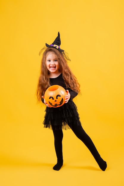 Menina bonitinha com fantasia de bruxa de Halloween