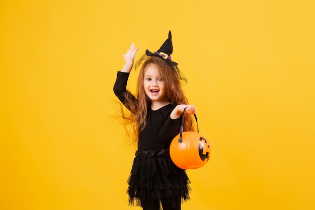 Menina bonitinha com fantasia de bruxa de Halloween