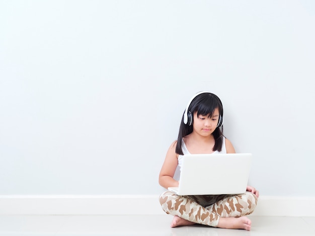 Menina bonitinha com laptop em casa