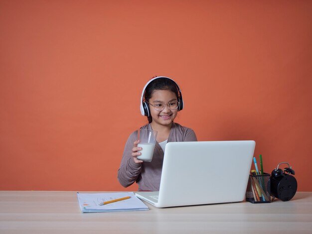 Menina bonitinha com laptop na mesa