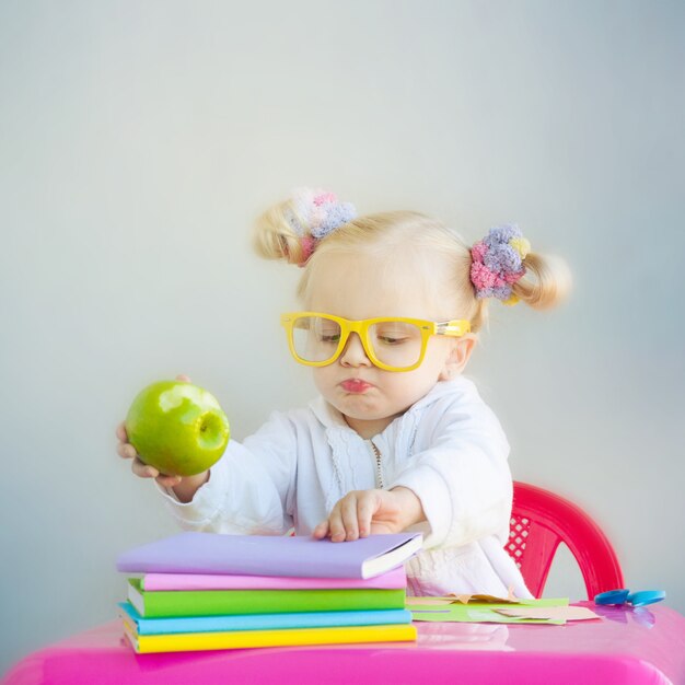 Foto menina bonitinha com livros e maçã verde