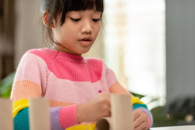 Menina bonitinha com núcleo de tecido pintado a arte faz as crianças aprenderem e criarem