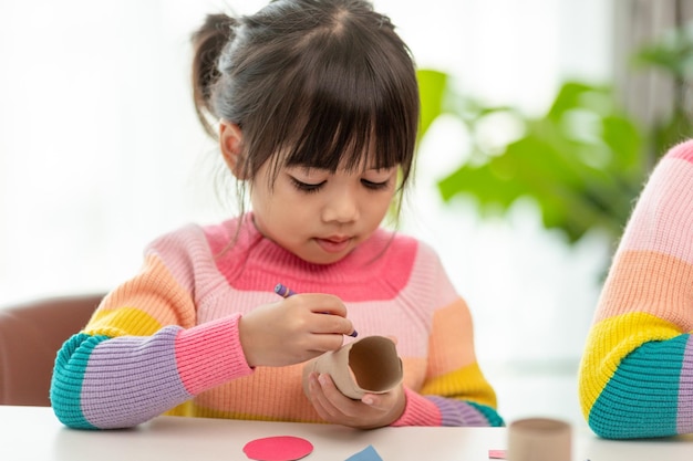 Menina bonitinha com núcleo de tecido pintado A arte faz as crianças aprenderem e criarem