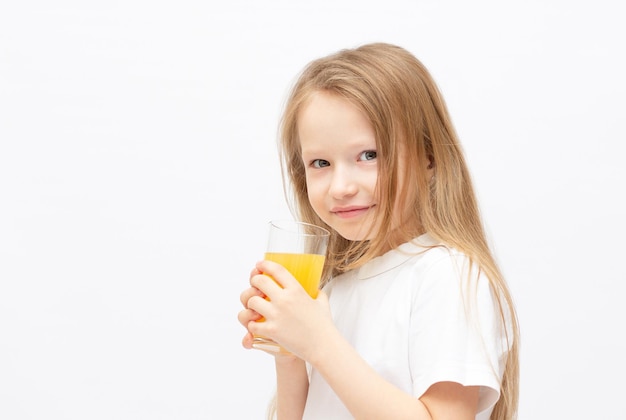 Menina bonitinha com o suco de laranja