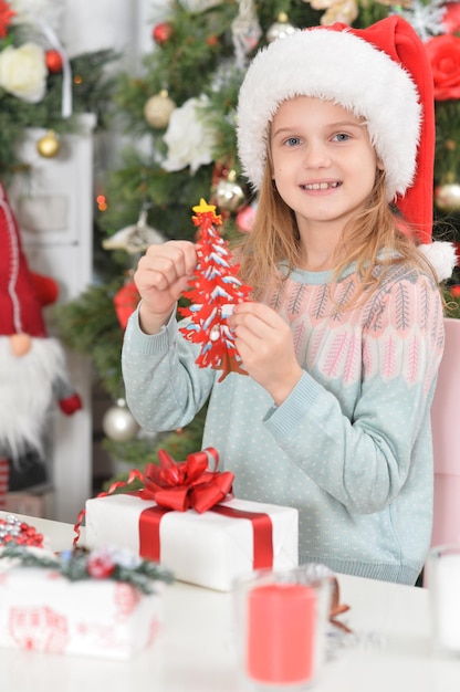 Menina bonitinha com presentes de ano novo com chapéu de Papai Noel