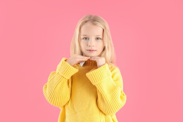 Menina bonitinha com suéter em fundo rosa