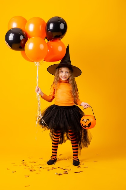 Menina bonitinha com uma fantasia de bruxa para o Halloween