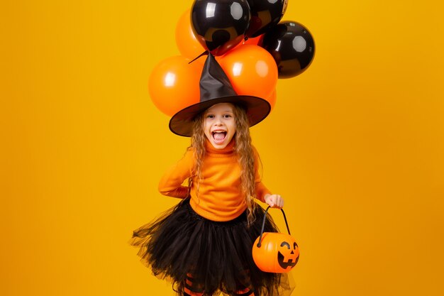 Menina bonitinha com uma fantasia de bruxa para o Halloween