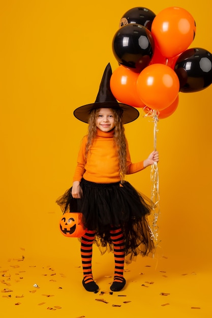 Menina bonitinha com uma fantasia de bruxa para o Halloween