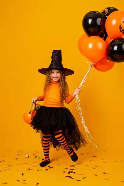 Menina bonitinha com uma fantasia de bruxa para o Halloween