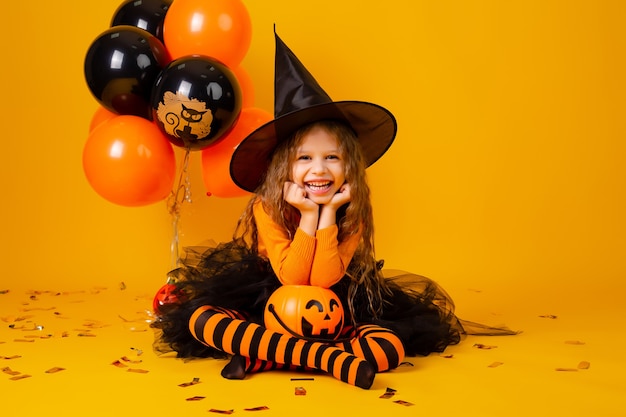 Menina bonitinha com uma fantasia de bruxa para o Halloween