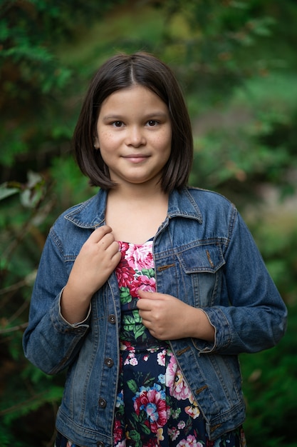 Menina bonitinha com vestido xadrez e jaqueta jeans