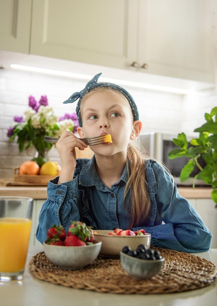 Menina bonitinha come salada de frutas